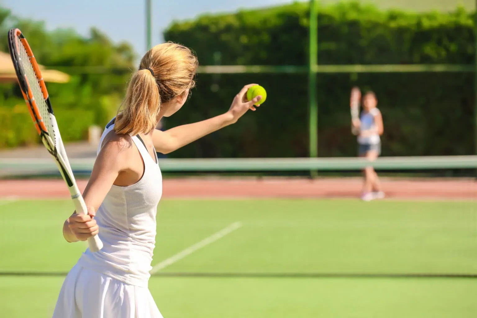 Young woman playing tennis on court