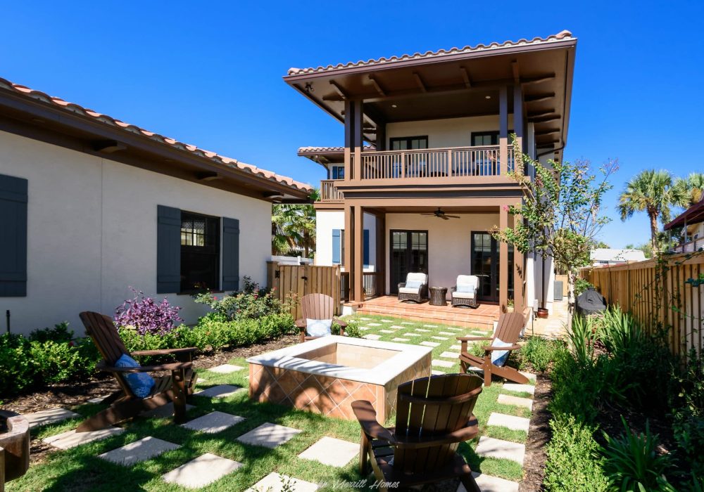 Classic modern two-story home with a spacious backyard patio, outdoor seating, lush garden, and a fire pit, showcasing quality craftsmanship and inviting outdoor living space.