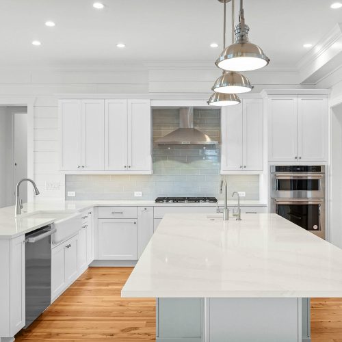 Bright, spacious kitchen featuring white cabinetry, a large island, and stainless steel appliances, perfect for cooking and entertaining.