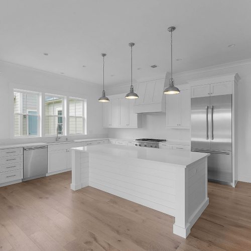Bright and spacious kitchen featuring white cabinetry, a large island, and stainless steel appliances, perfect for family cooking and entertaining.