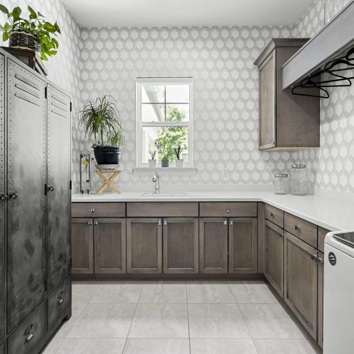 Bright kitchen featuring gray cabinets, white countertops, and a window with natural light.