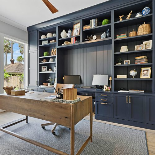 Bright and stylish workspace featuring custom cabinetry, ample natural light, and organized shelving for a productive lifestyle.