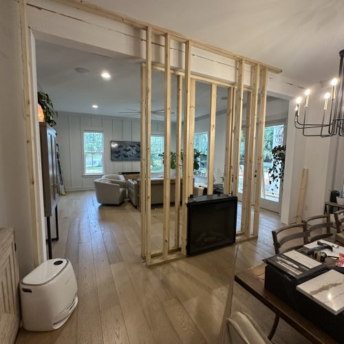 1. Unfinished wooden wall frame inside a modern living room during home construction or renovation.