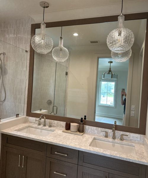 Elegant bathroom featuring a double sink vanity with a large mirror and stylish pendant lights.