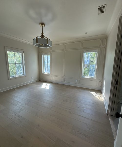 Bright and spacious living room featuring three large windows that allow ample natural light, white walls, and light wood flooring, creating a clean and airy atmosphere perfect for relaxation and ente.