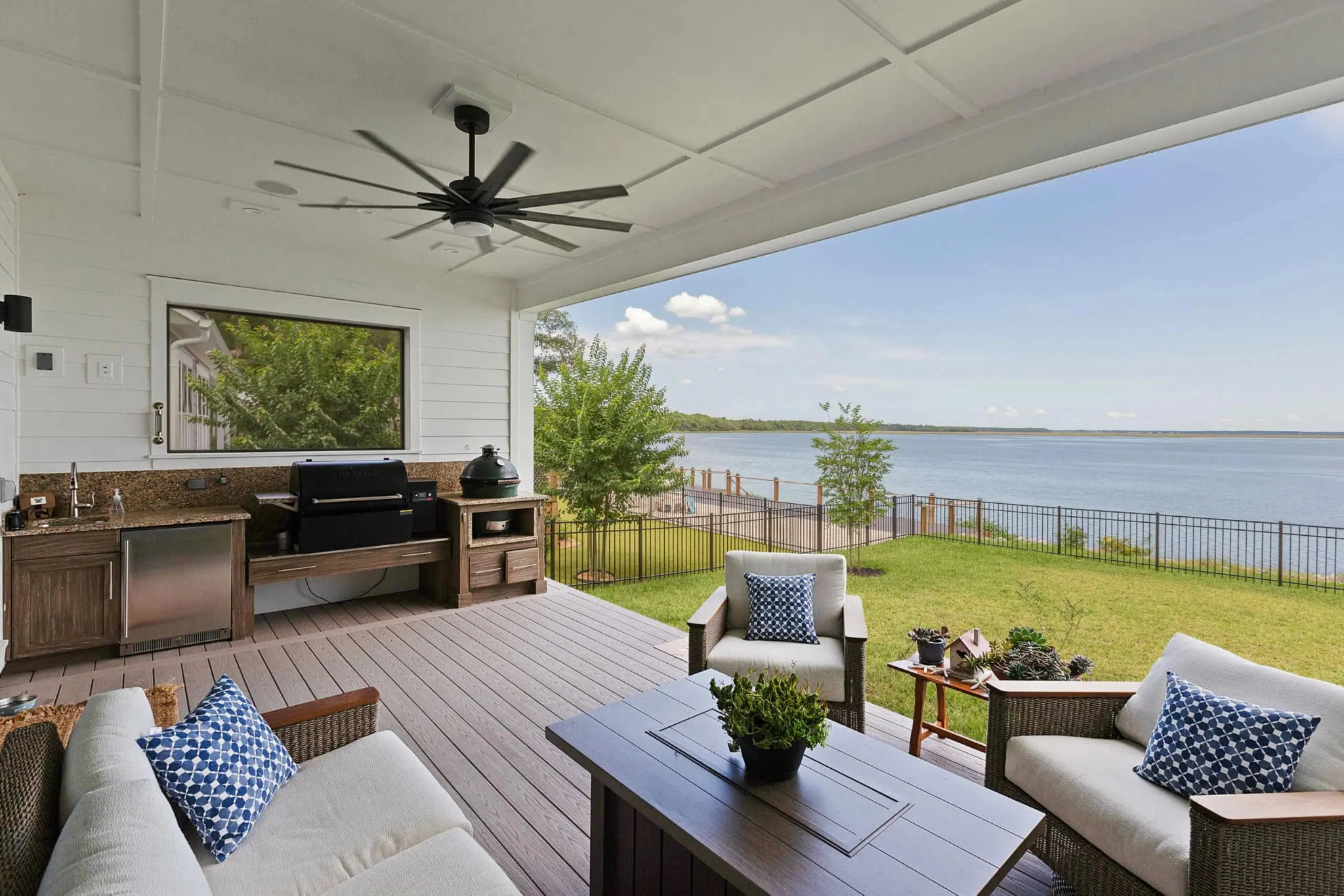 Bright screened-in porch with seating area and pool, surrounded by lush greenery and trees.